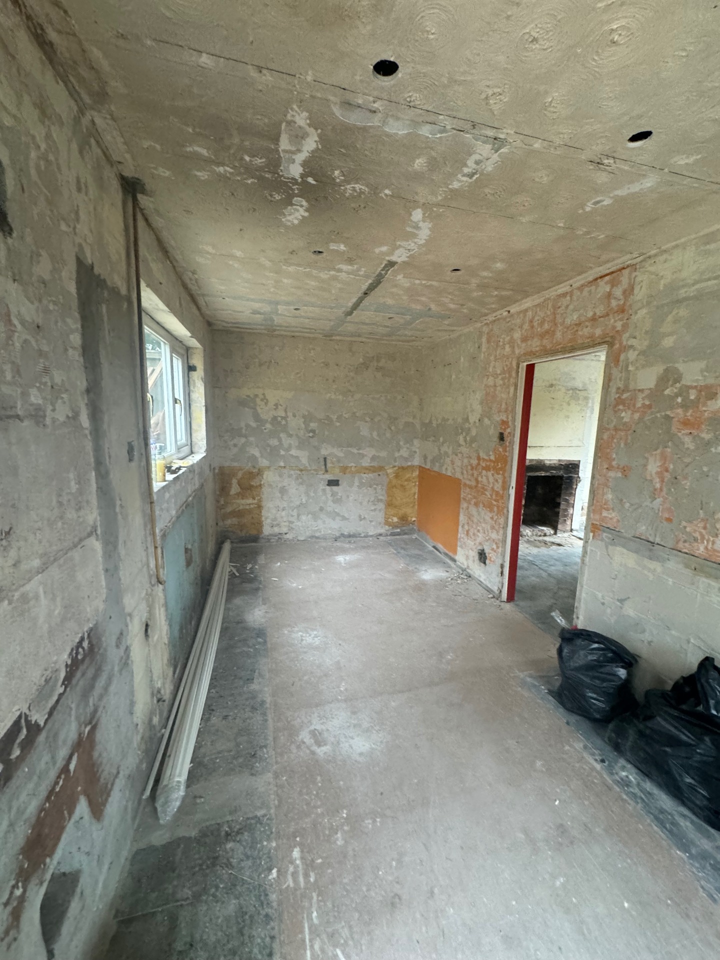 Living room before the rewire — stripped walls and bare floor