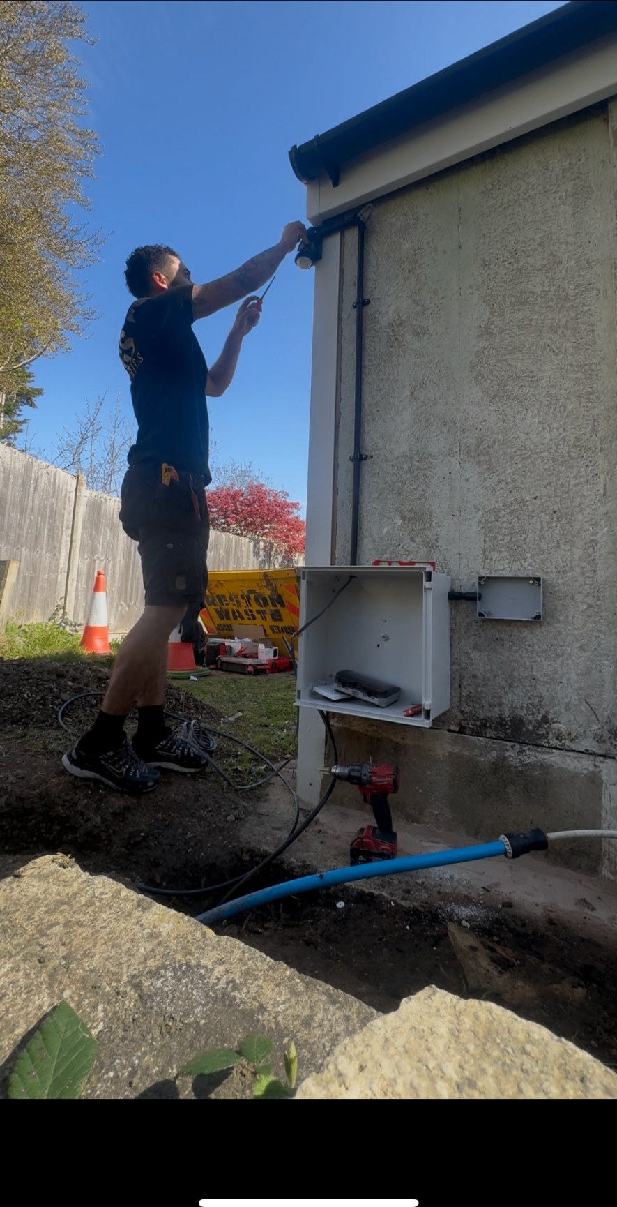 DGS electrician installing an outdoor security light on a Surrey property